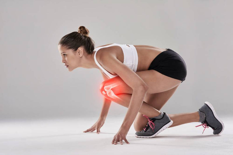 Woman in athletic wear performing a dash with highlighted knee bone in red  on a gray background indicating knee issue.
